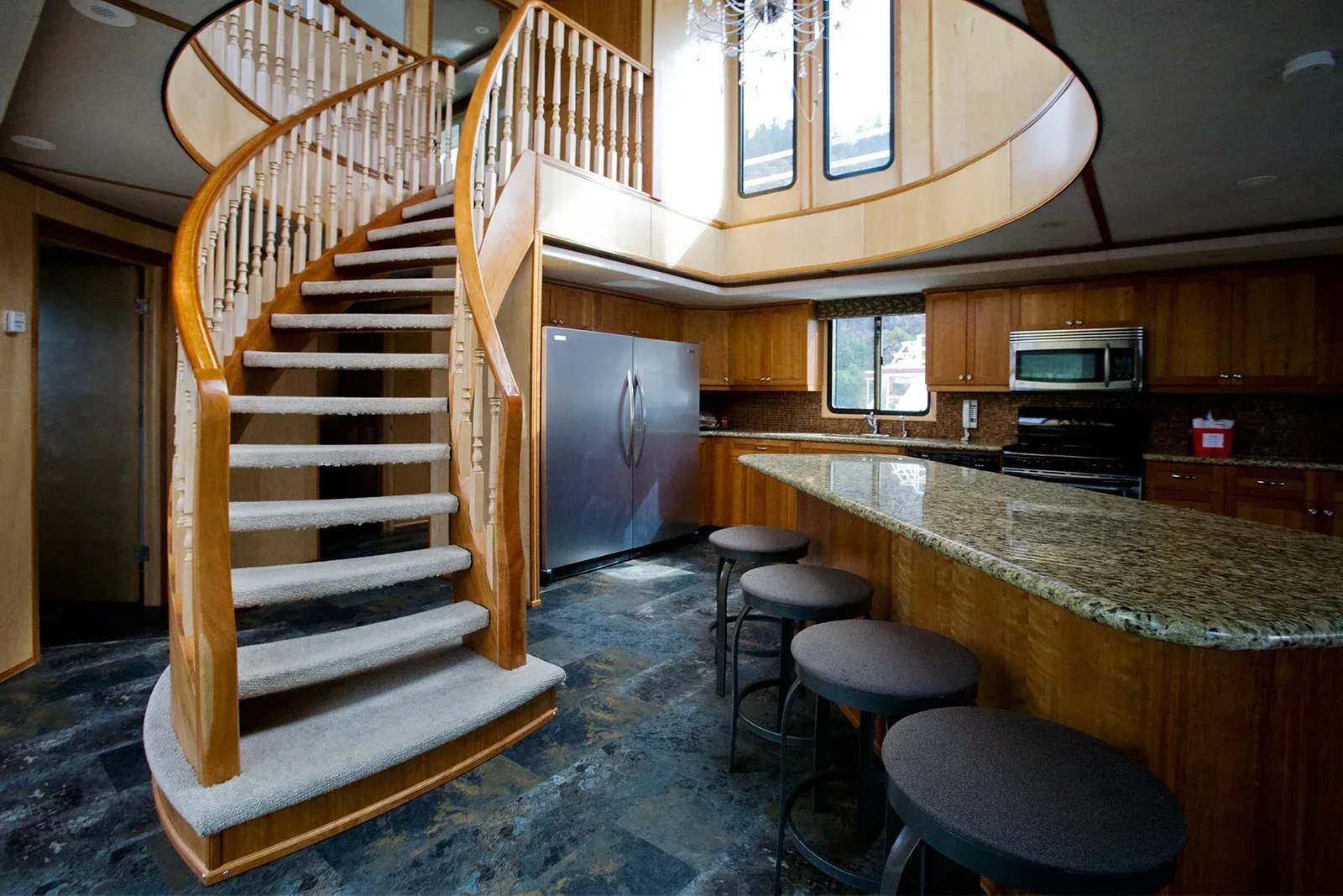 A kitchen with a spiral staircase leading up to the second floor