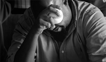 A black and white photo of a man drinking from a cup