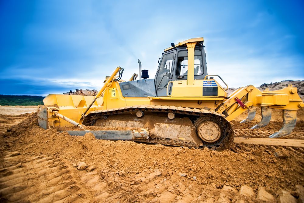 A Bulldozer is Moving Dirt on a Construction Site — Dino's Bobcat–Bitumen & Excavator Hire in Cushnie, QLD