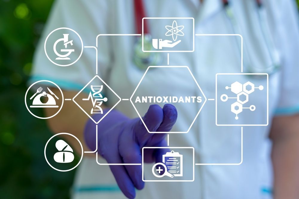 A doctor wearing purple gloves is pointing at a diagram of antioxidants.