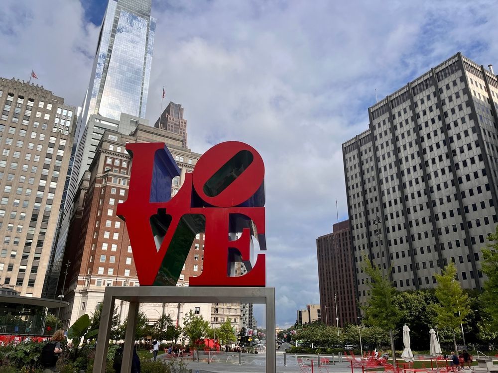 A large red love sign in front of a city skyline