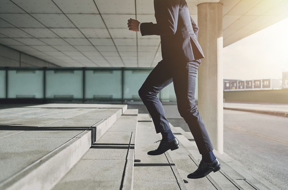 A man in a suit is running up a set of stairs.