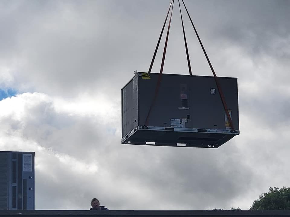 A large black box is being lifted by a crane.