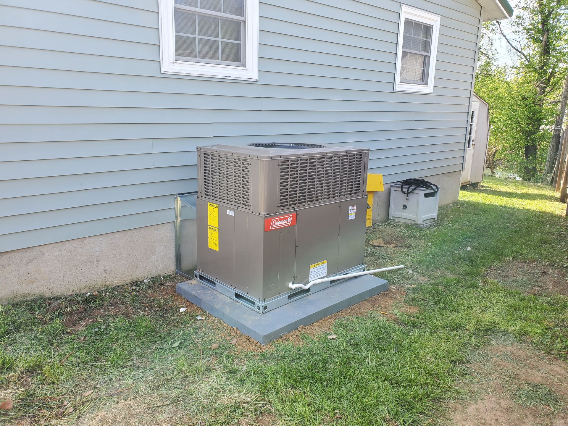 An air conditioner is sitting on the side of a house.
