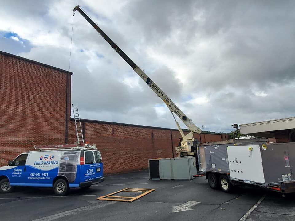 A crane is being used to lift a van in a parking lot.