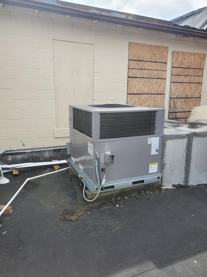 A large air conditioner is sitting outside of a building.