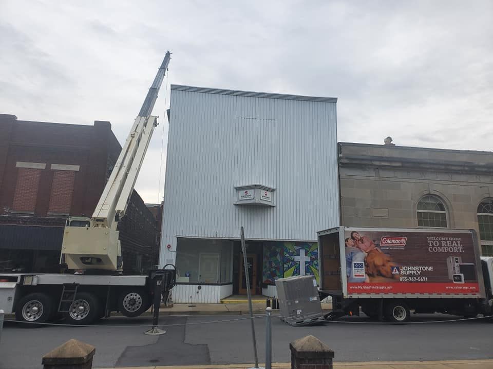A crane is lifting a sign on the side of a building