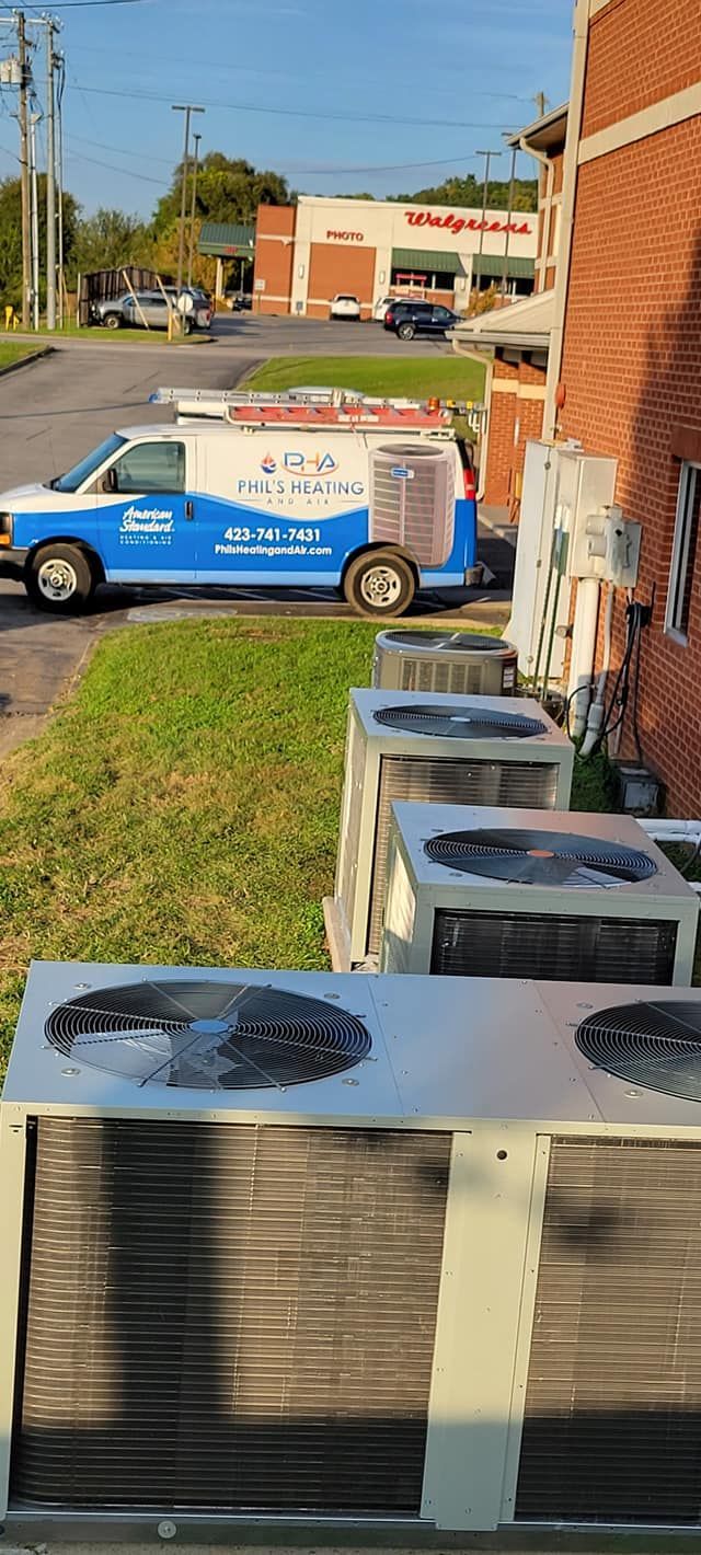 A blue and white van is parked next to a row of air conditioners.