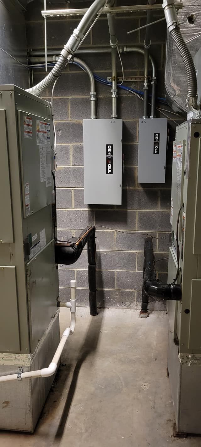 A room with a lot of electrical equipment and a brick wall.