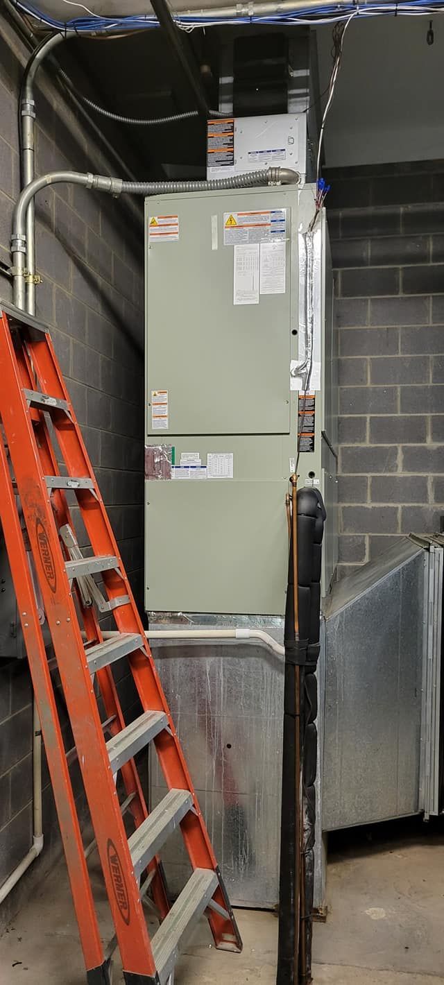 A ladder is sitting next to a furnace in a room.