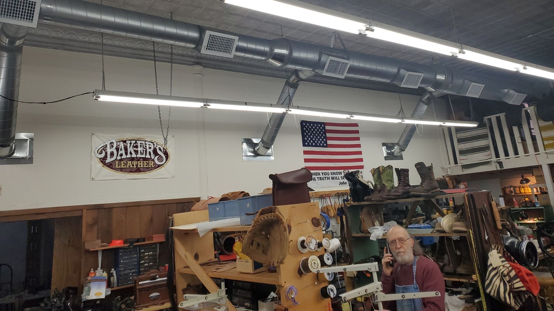 A man is working on a machine in a shoe repair shop.