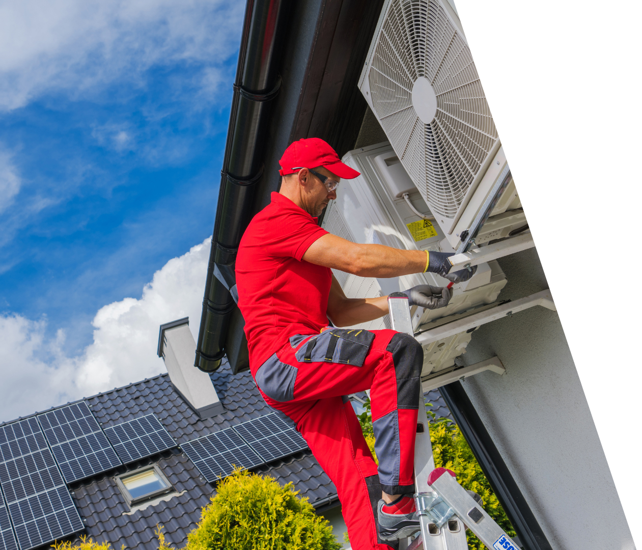 A man is working on an air conditioner on the side of a house.