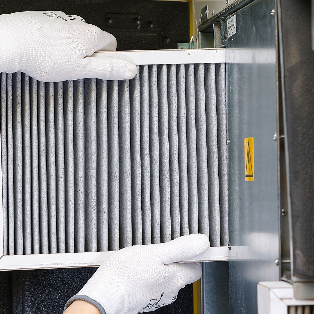 HVAC Technician installing a new air vent as part of Phil's Heating and Air's Preventative HVAC Maintenance Services