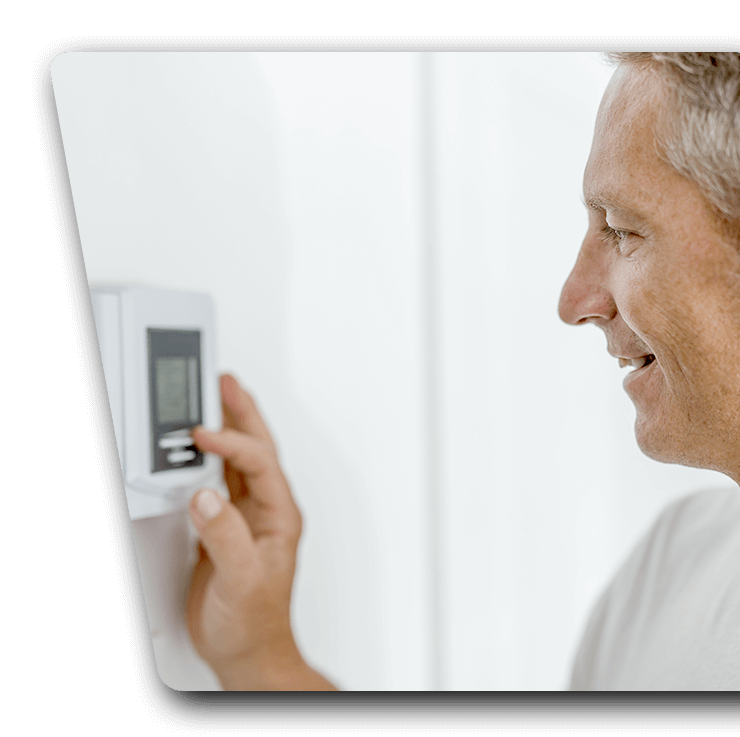 A man adjusting his new digital thermostat from Phil's Heating and Air