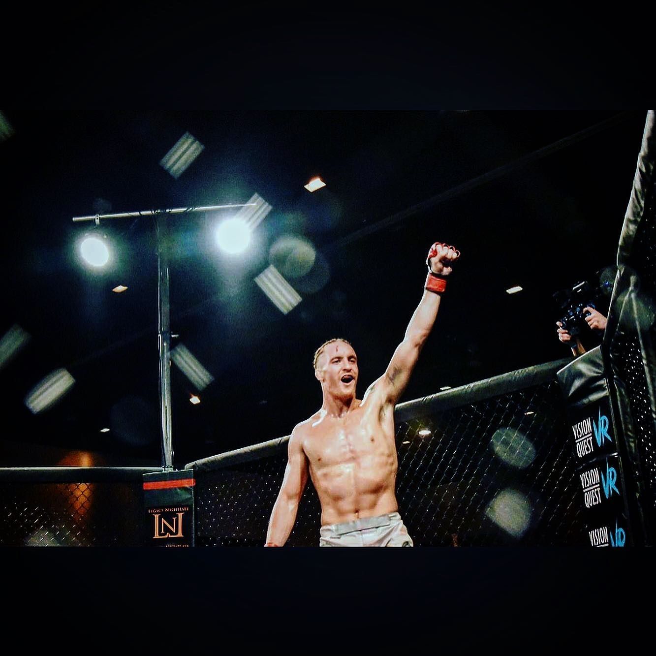 A man in a boxing ring with his arm in the air