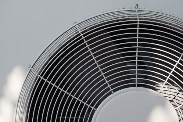 A close up of a fan on a white wall.