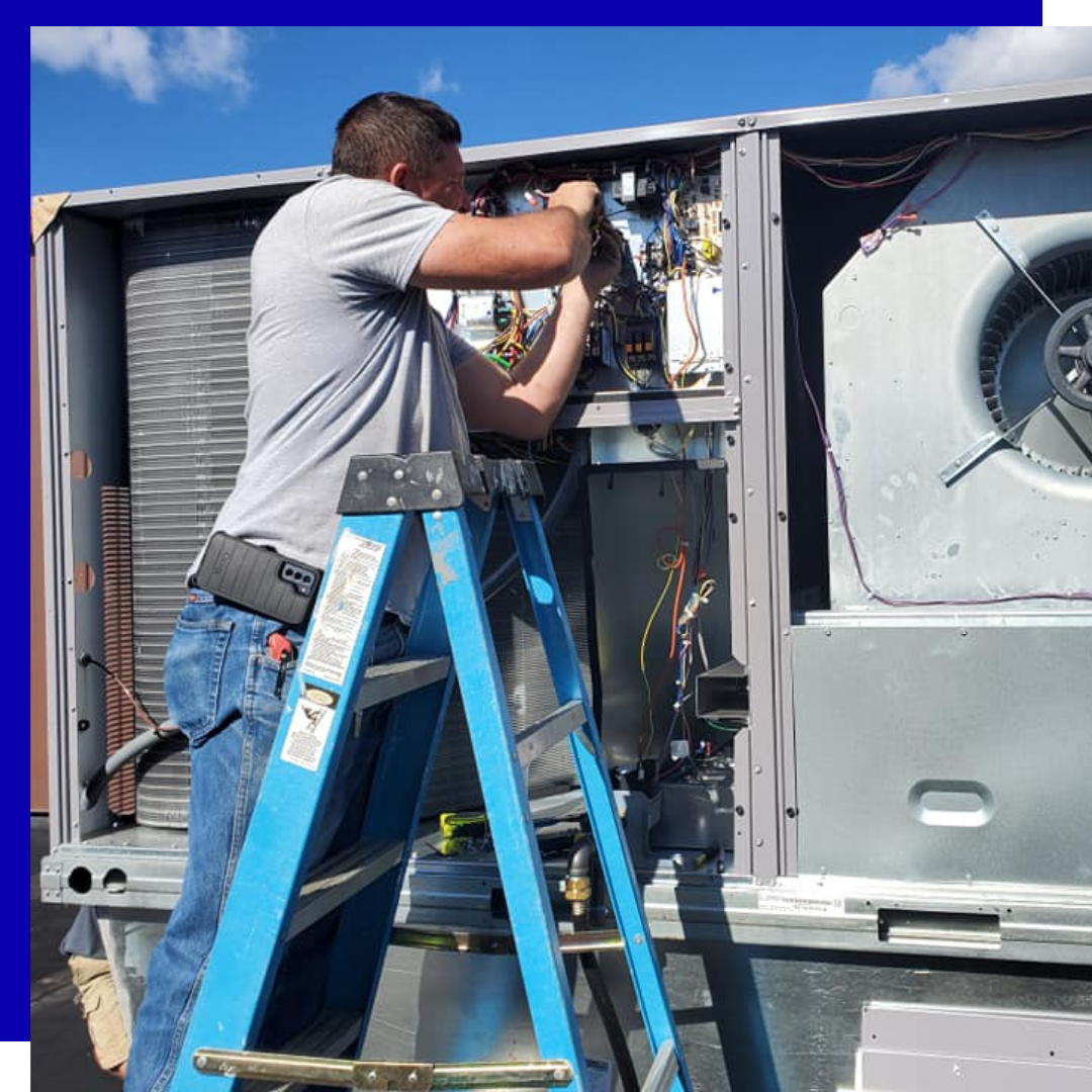 A man on a ladder working on an air conditioner