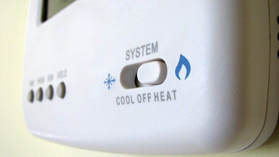 A close up of a system cool off heat thermostat