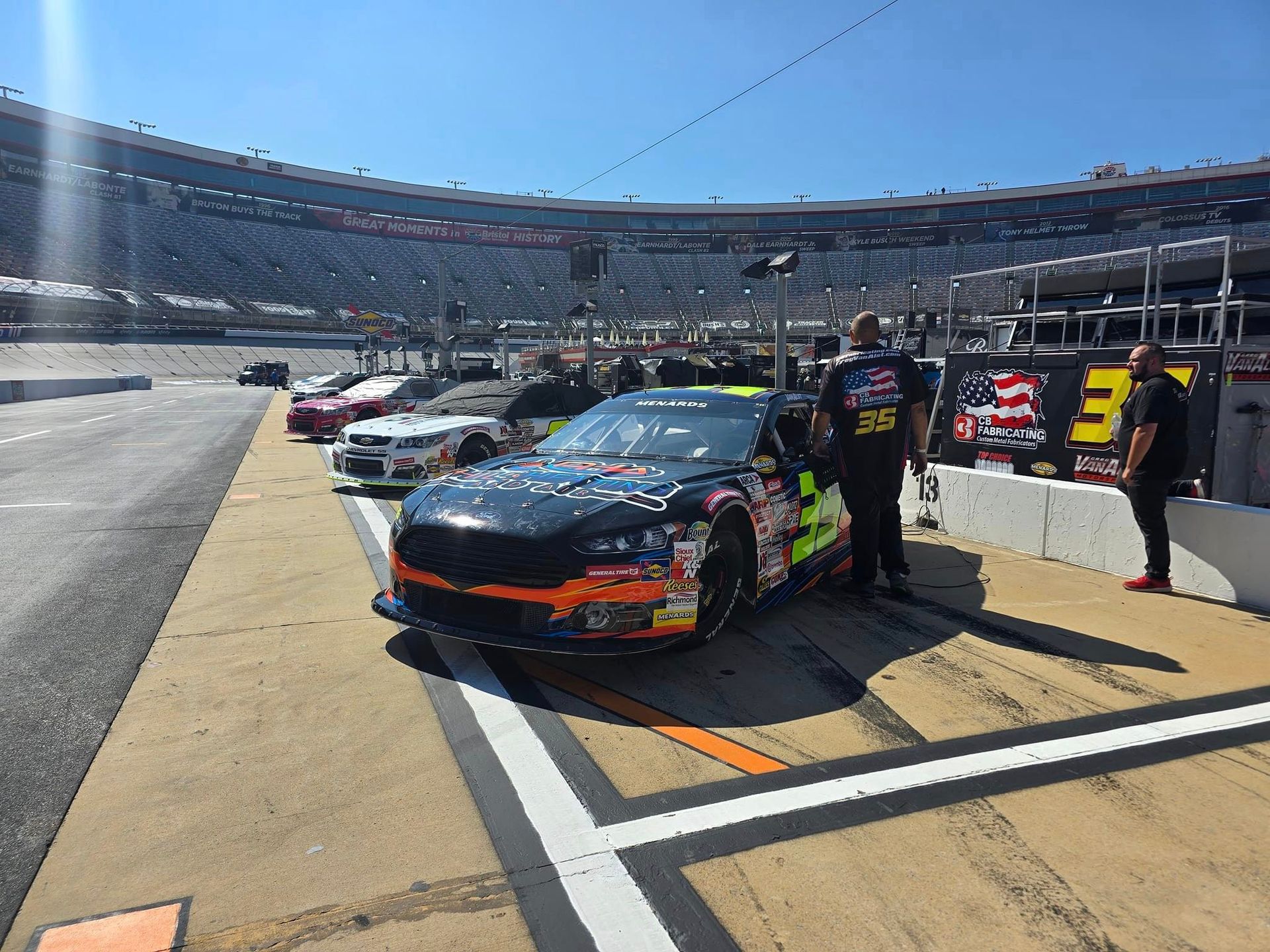 A race car is parked on the side of a race track.