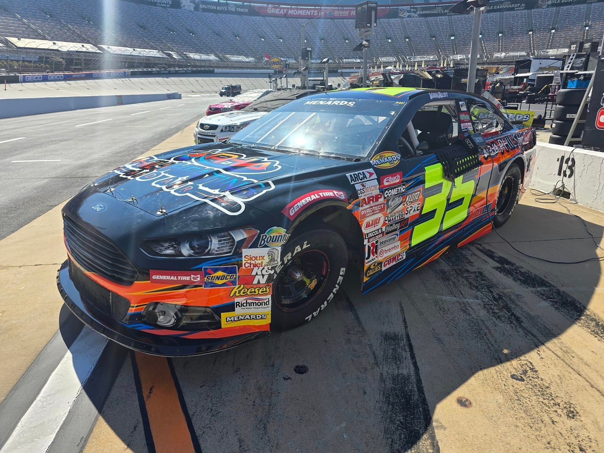 A race car is parked on the side of a race track.