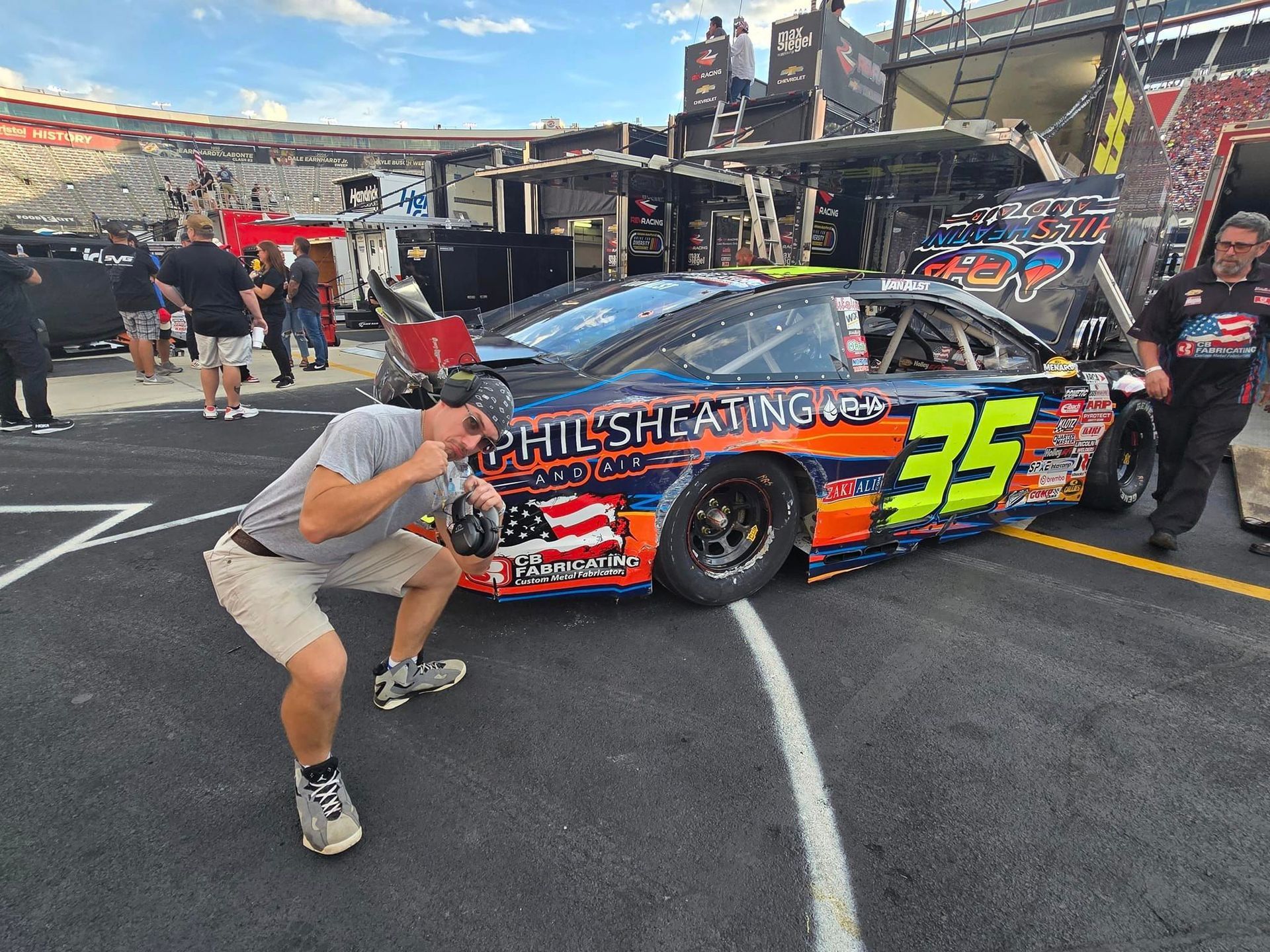 A man is standing in front of a race car with the number 35 on it.