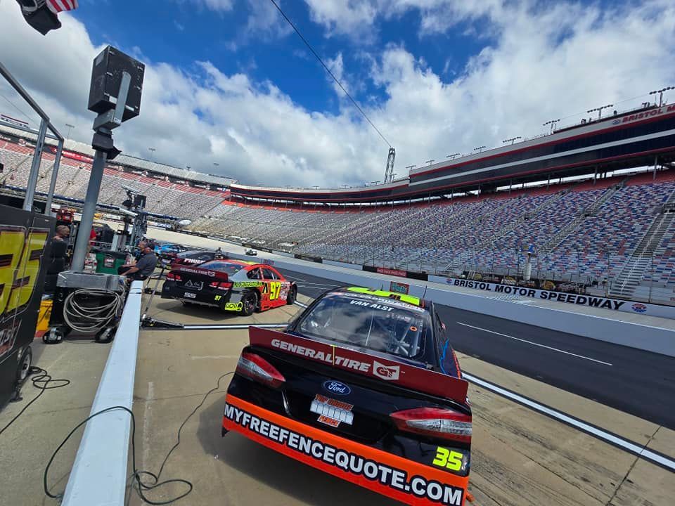 A race car is parked on the side of a race track.