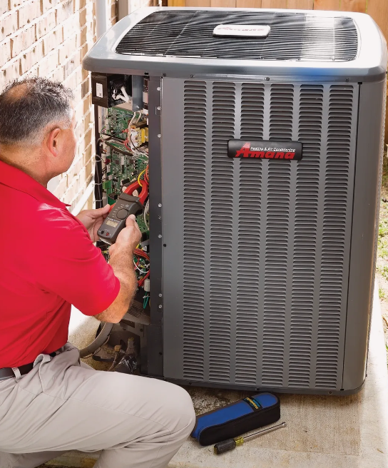 A man in a red shirt is working on an air conditioner