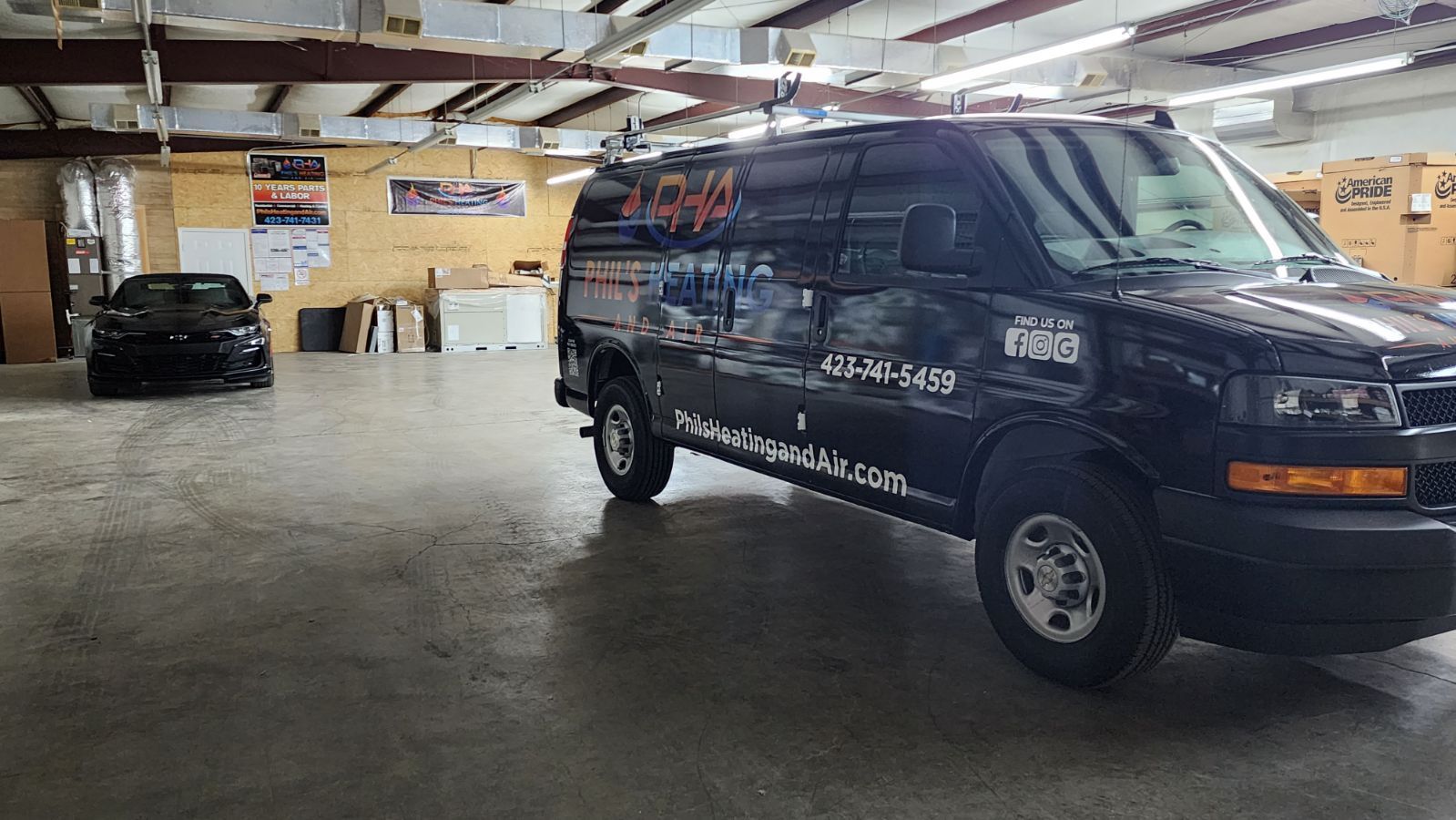 Phil's Heating and Air Van wrapped in PHA graphics inside of the HVAC shop