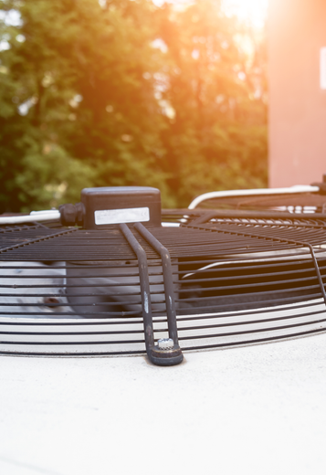 A close up of a well maintenanced HVAC fan on top of a  Tri-Cities building.