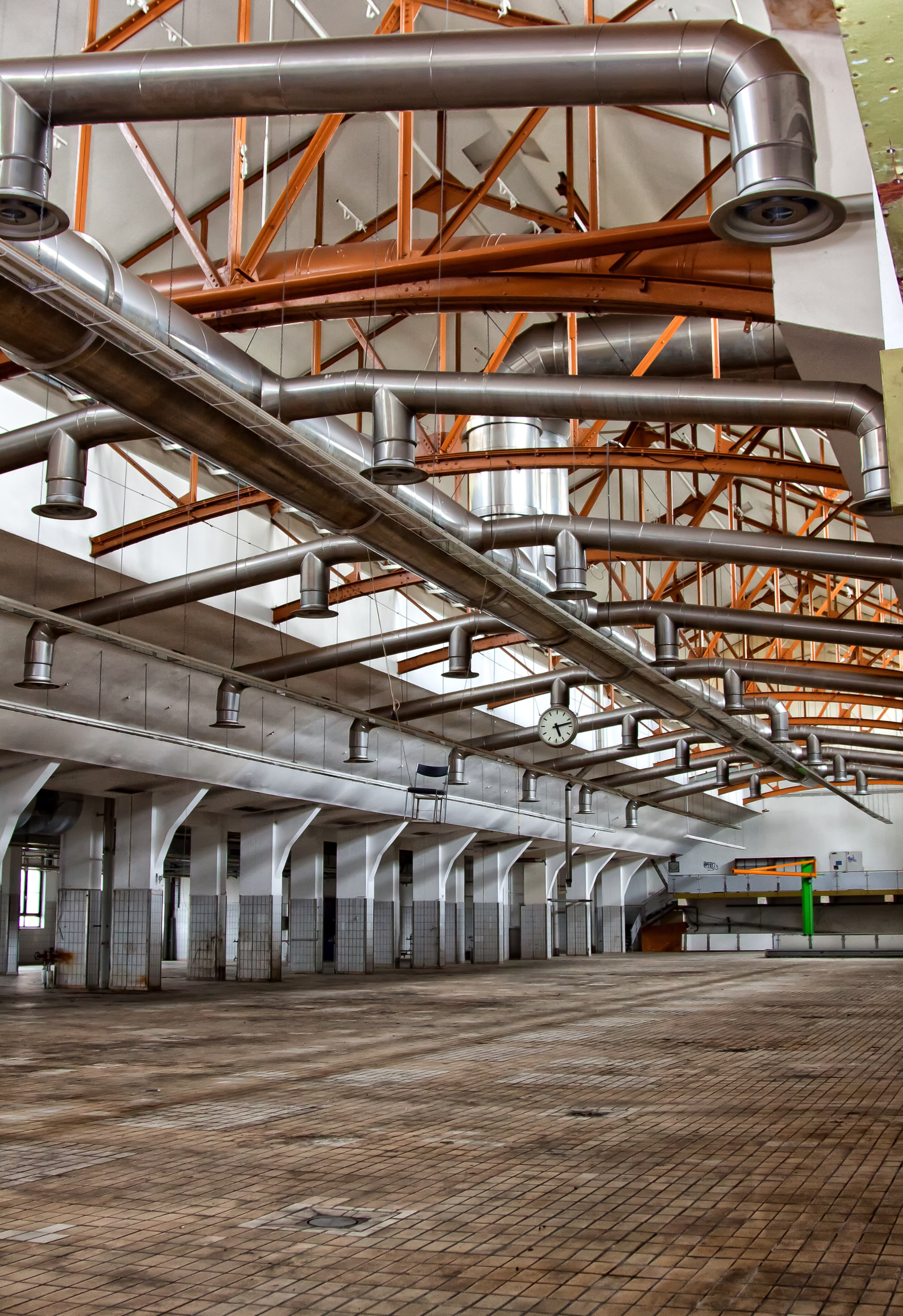 There are a lot of pipes hanging from the ceiling of a building.