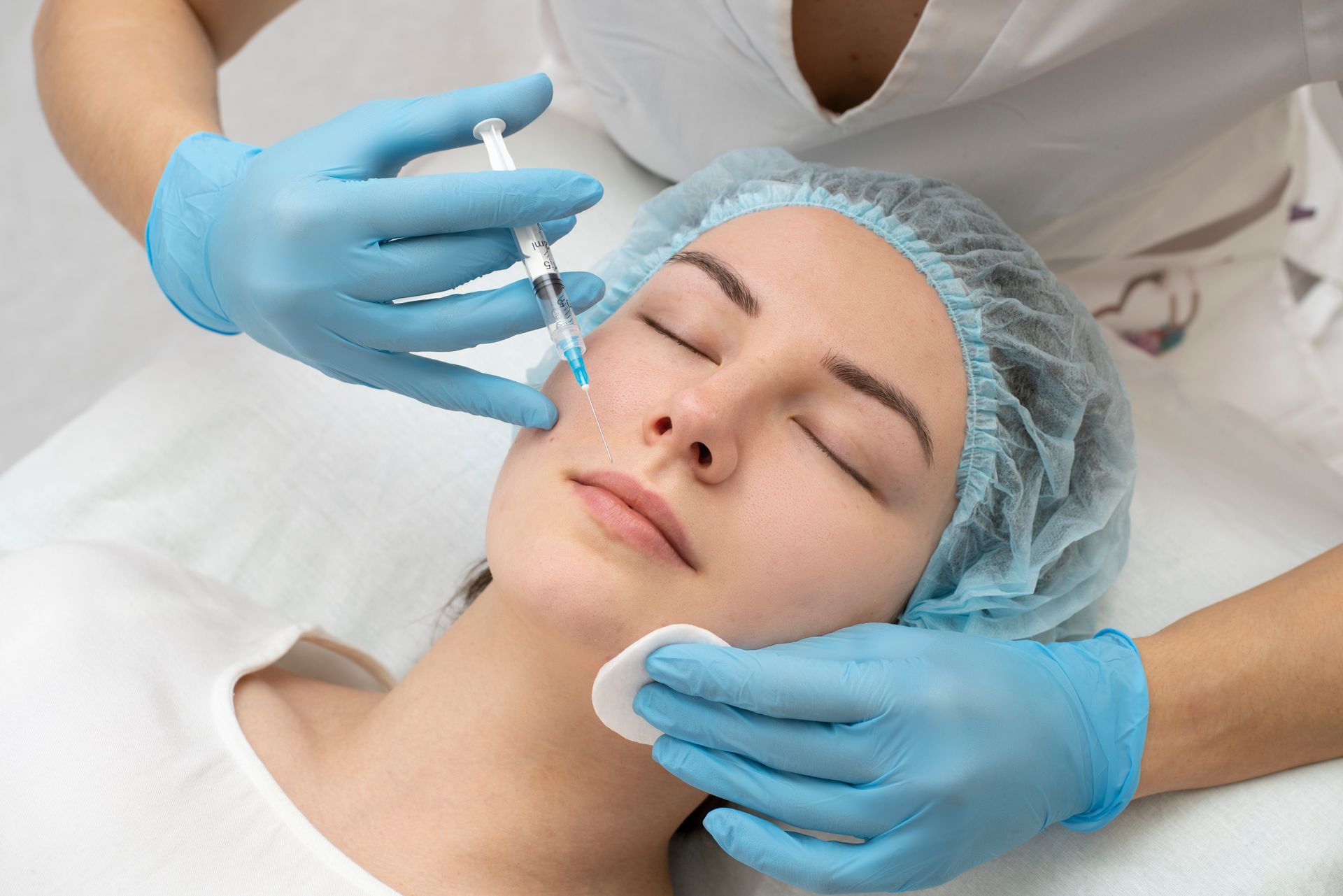 A woman is getting a botox injection in her face.