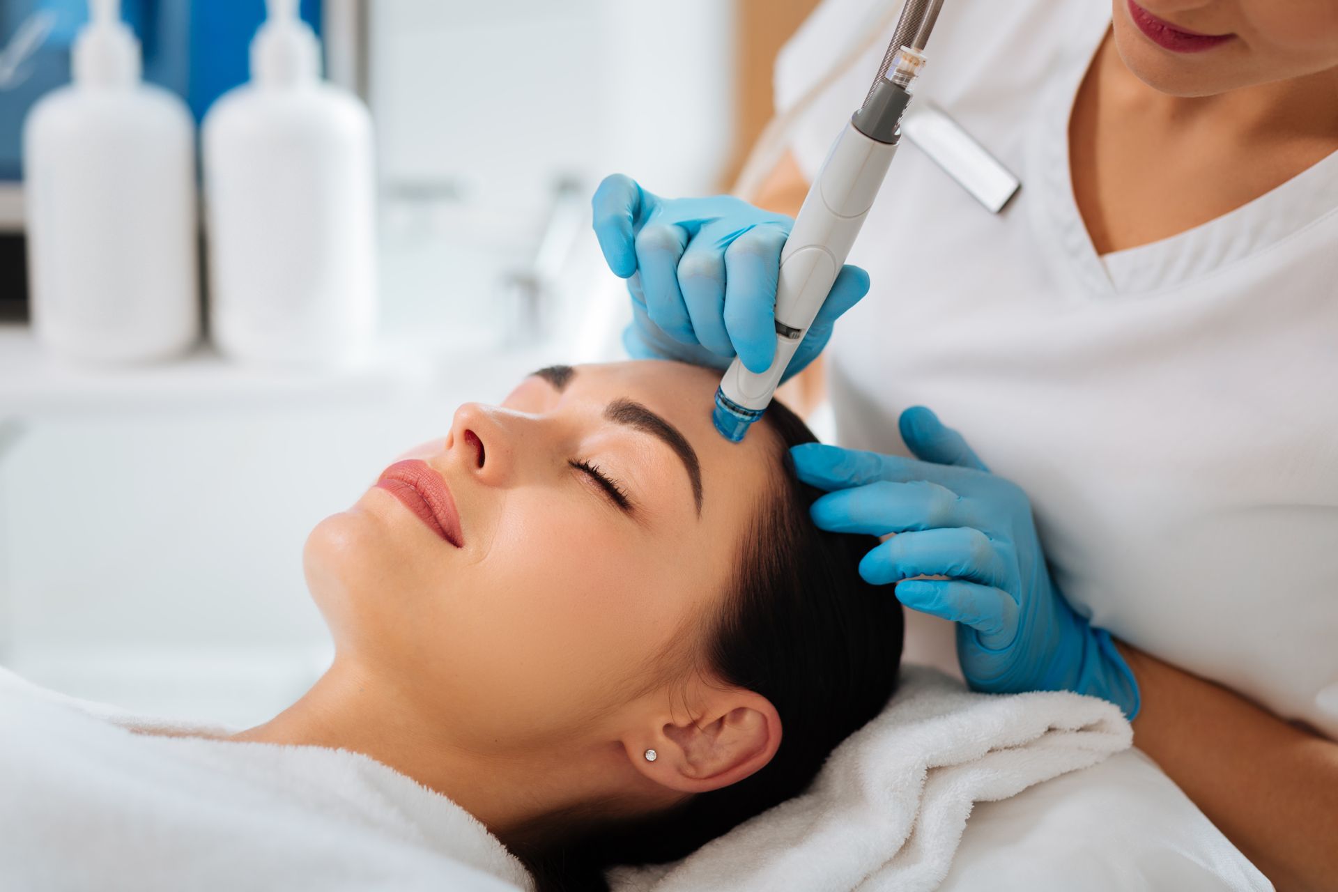 A woman is getting a facial treatment at a beauty salon.