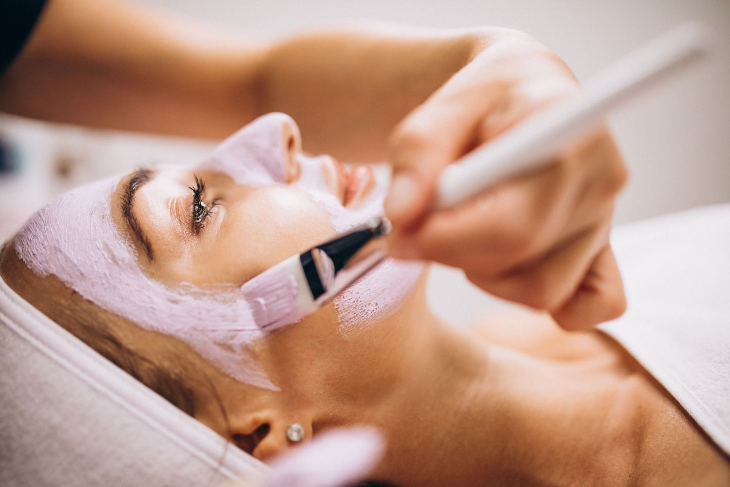 A woman is getting a facial treatment at a spa.