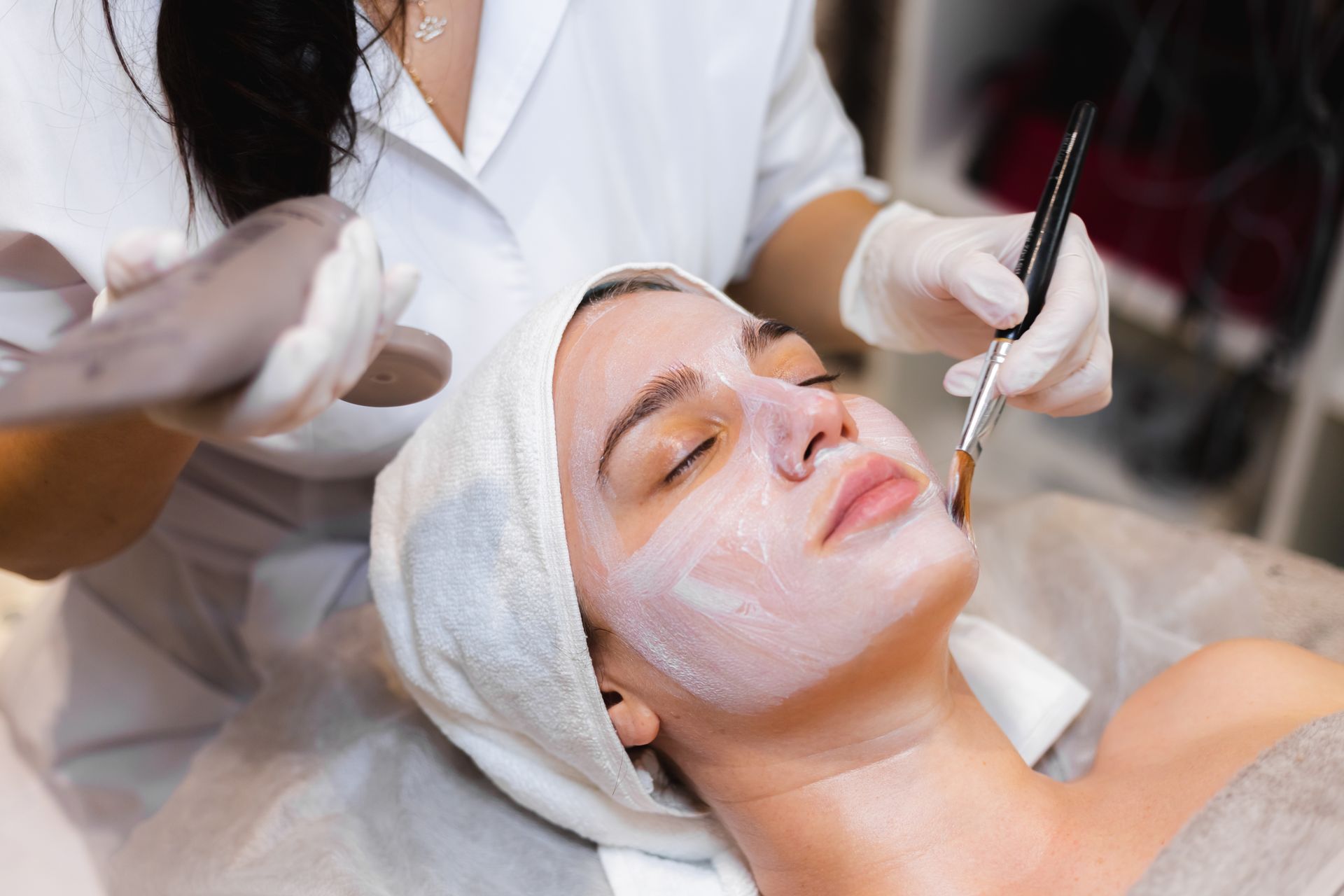 A woman is getting a facial treatment at a beauty salon.