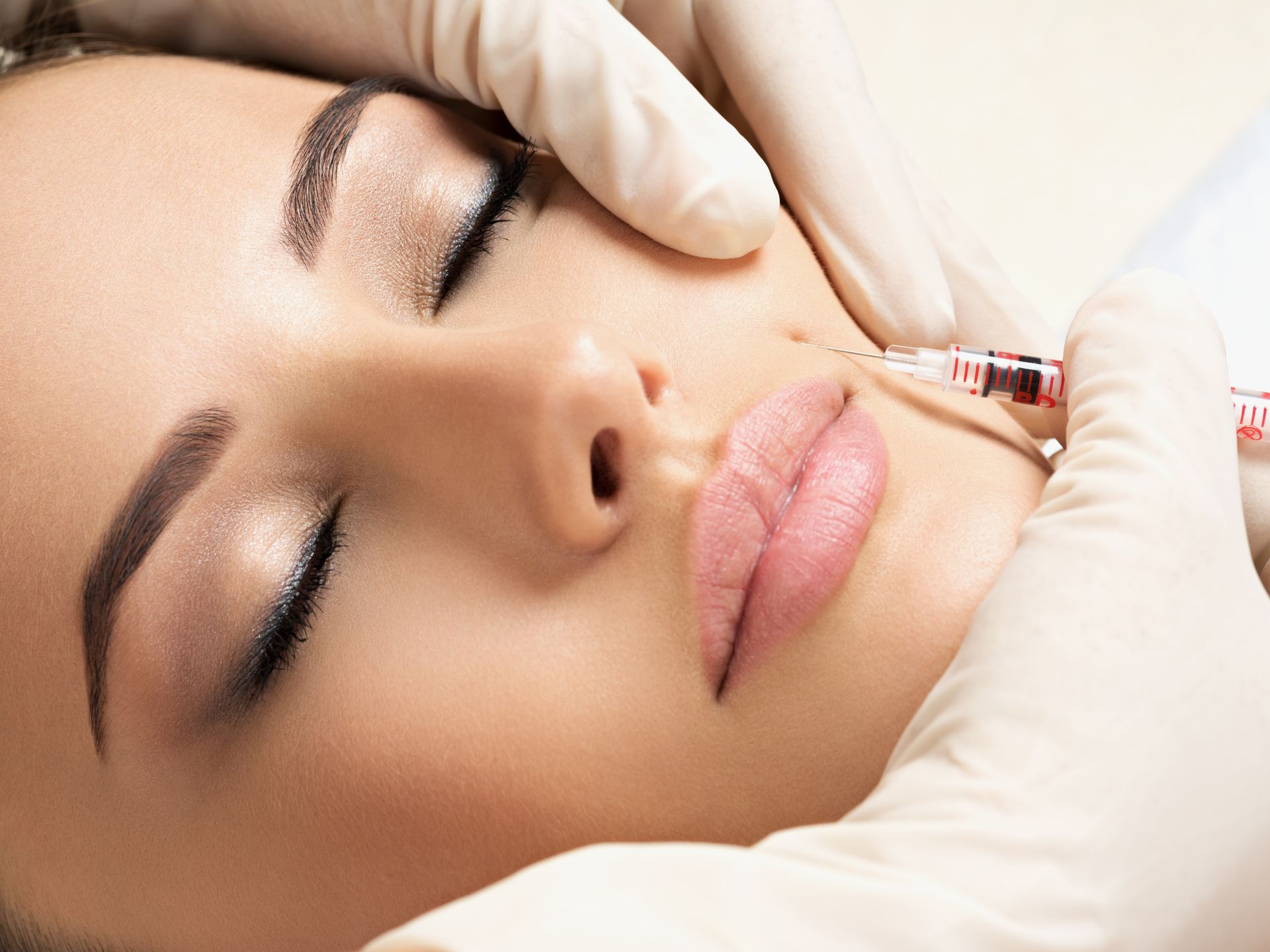 A woman is getting a botox injection in her face.