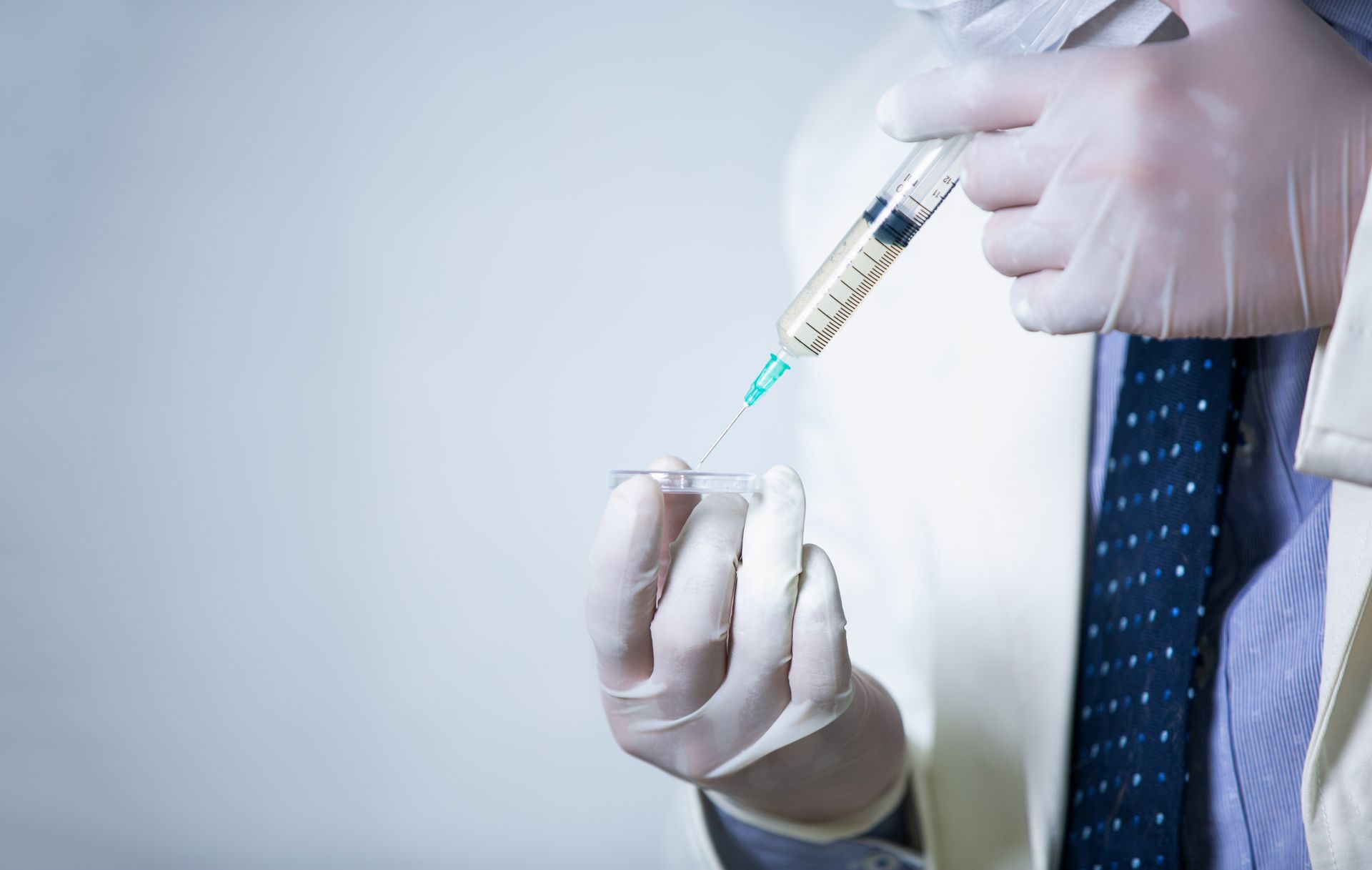 A doctor is preparing an injection with a syringe.