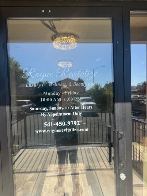 A glass door with rogue revitalize written on it