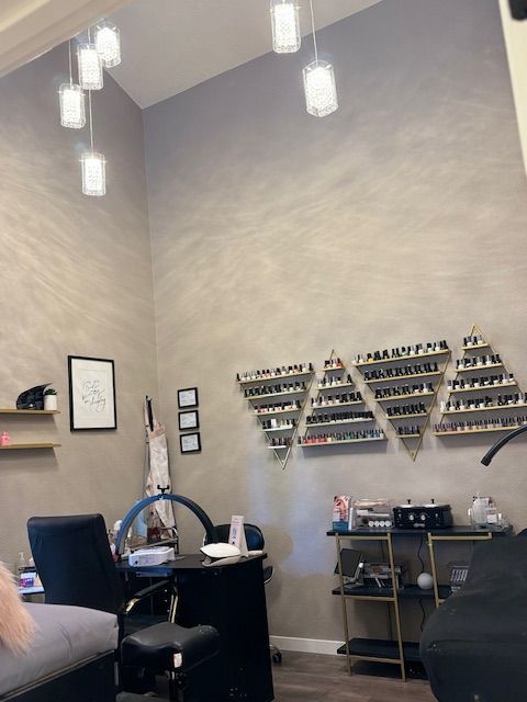 A woman is sitting in a chair in a nail salon.