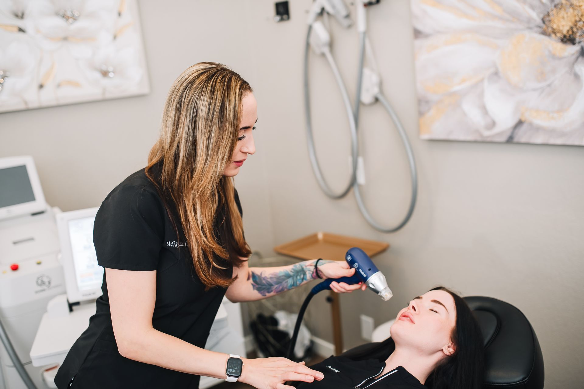 A woman is using a machine on a woman 's face in a beauty salon.