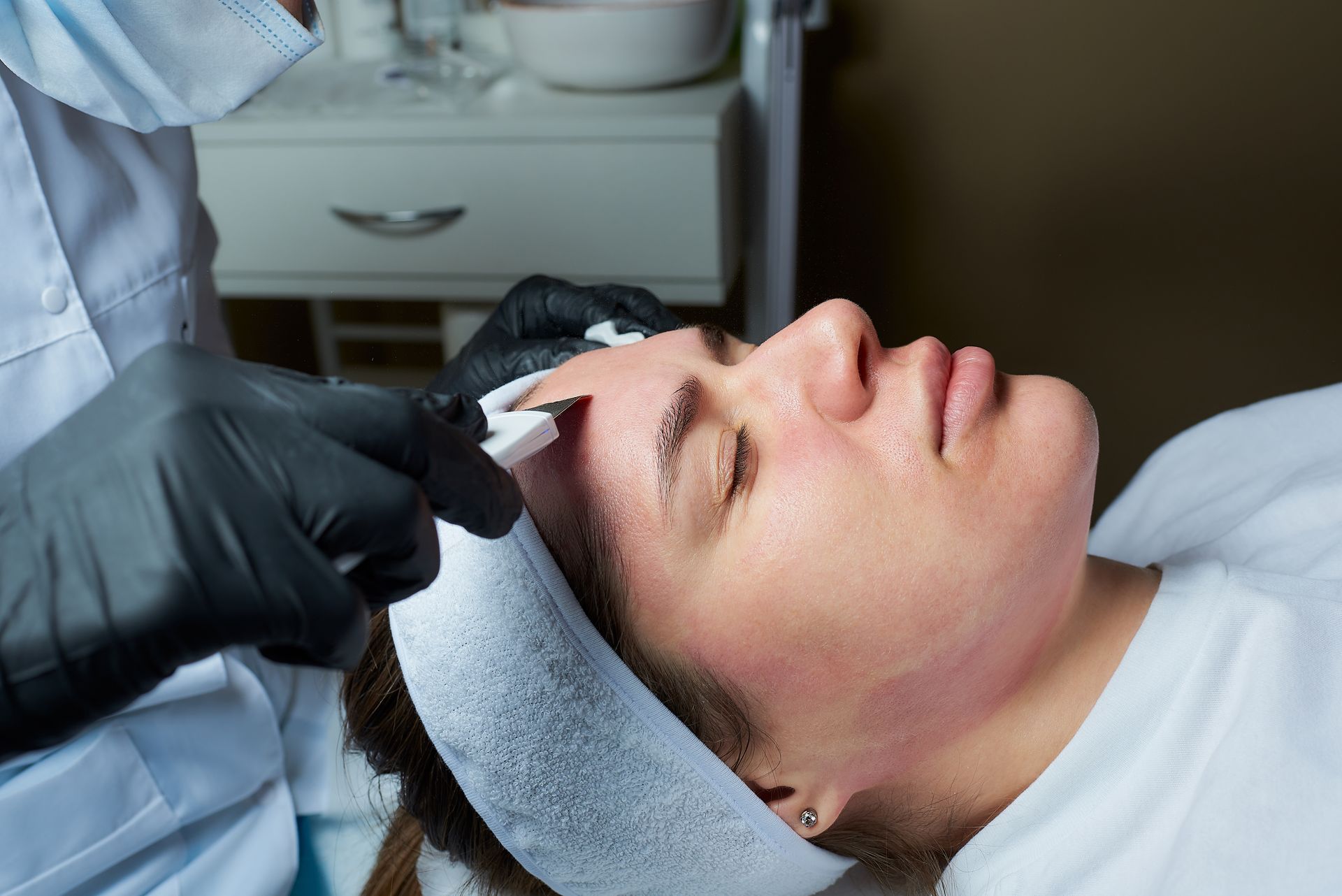 A woman is getting a facial treatment at a beauty salon.