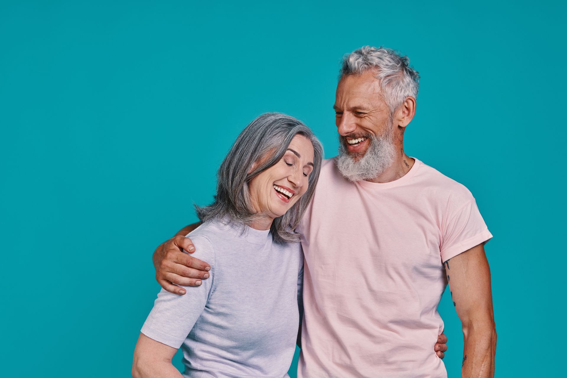 A man and a woman are hugging each other on a blue background.