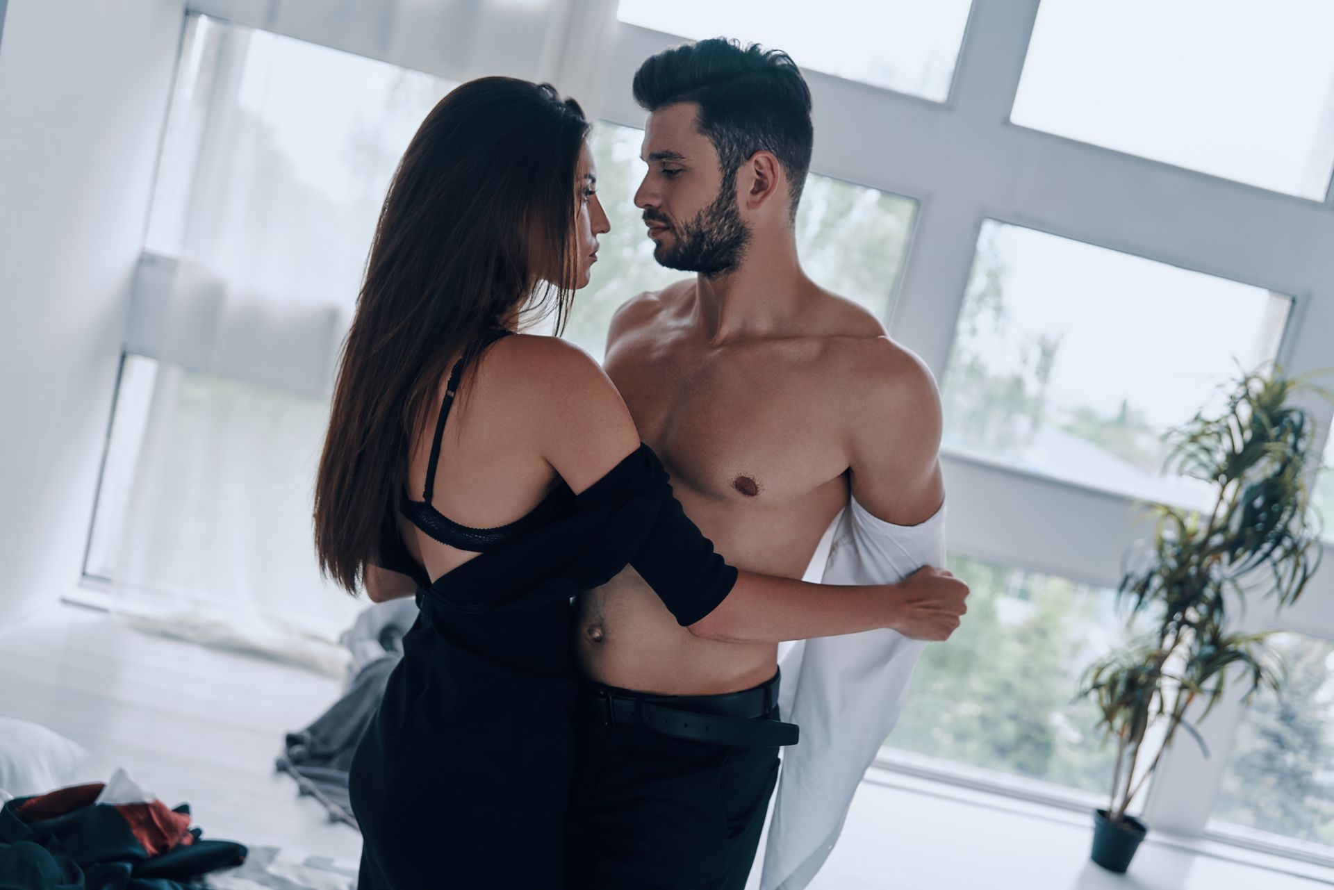 A man and a woman are standing next to each other in a room.