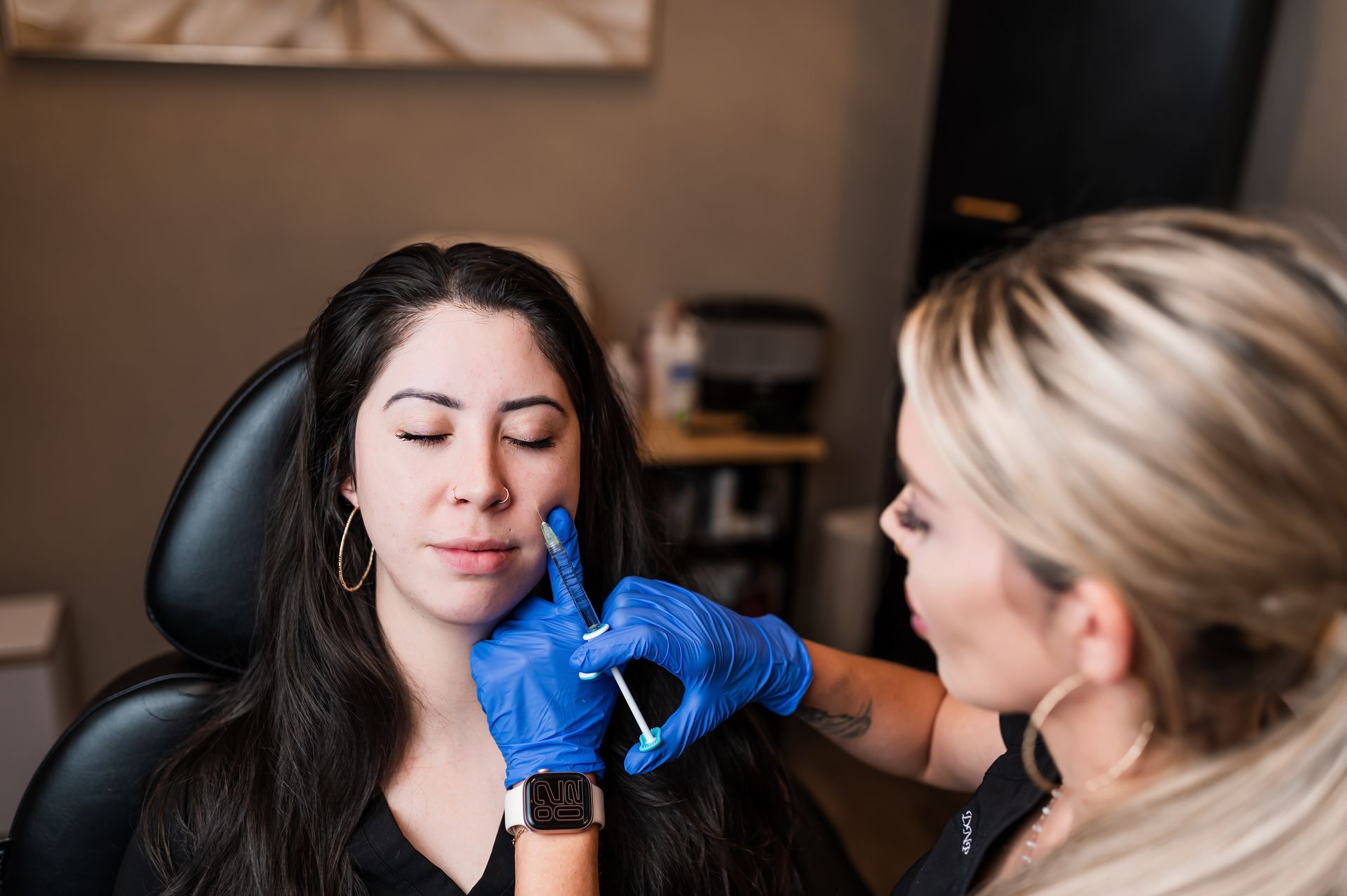 A woman is getting a botox injection in her face.
