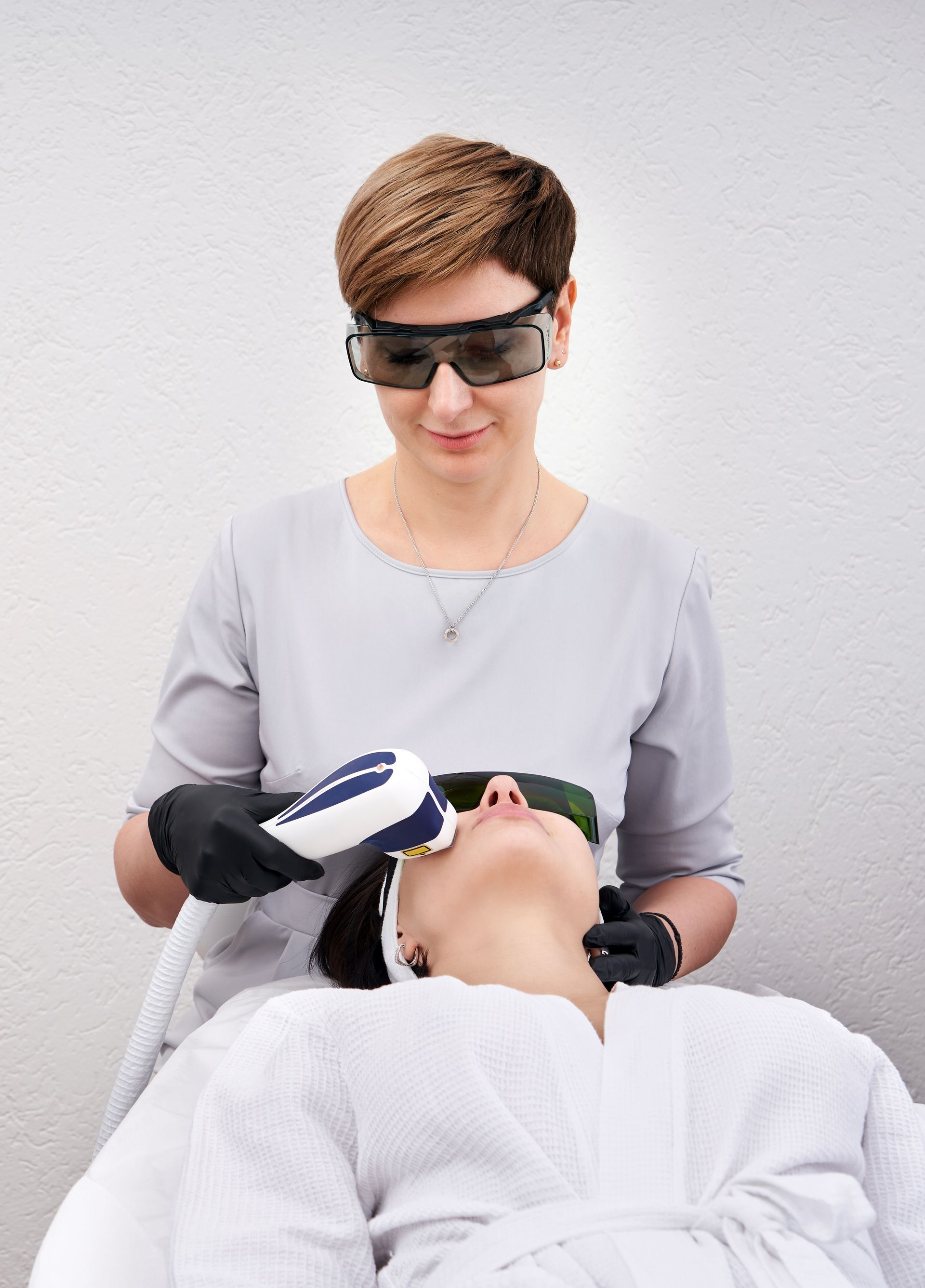 A woman is getting a laser treatment on her face.
