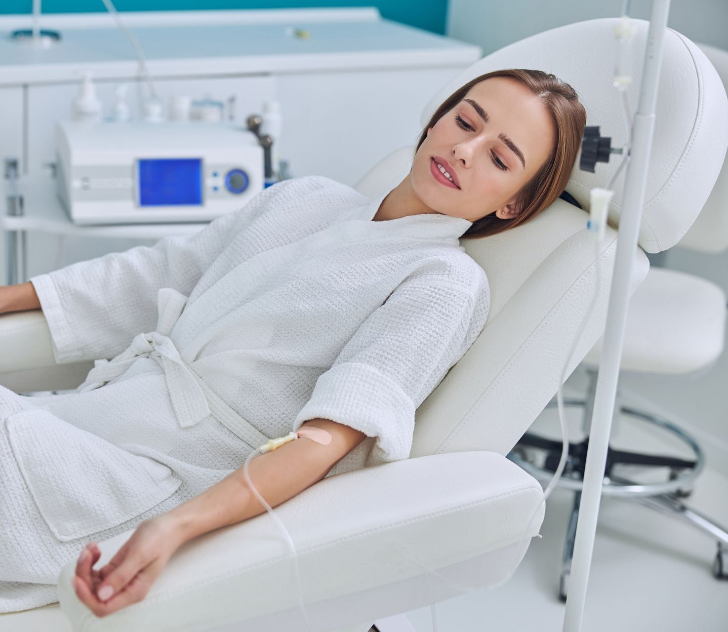 A woman is laying in a chair with an iv in her arm.