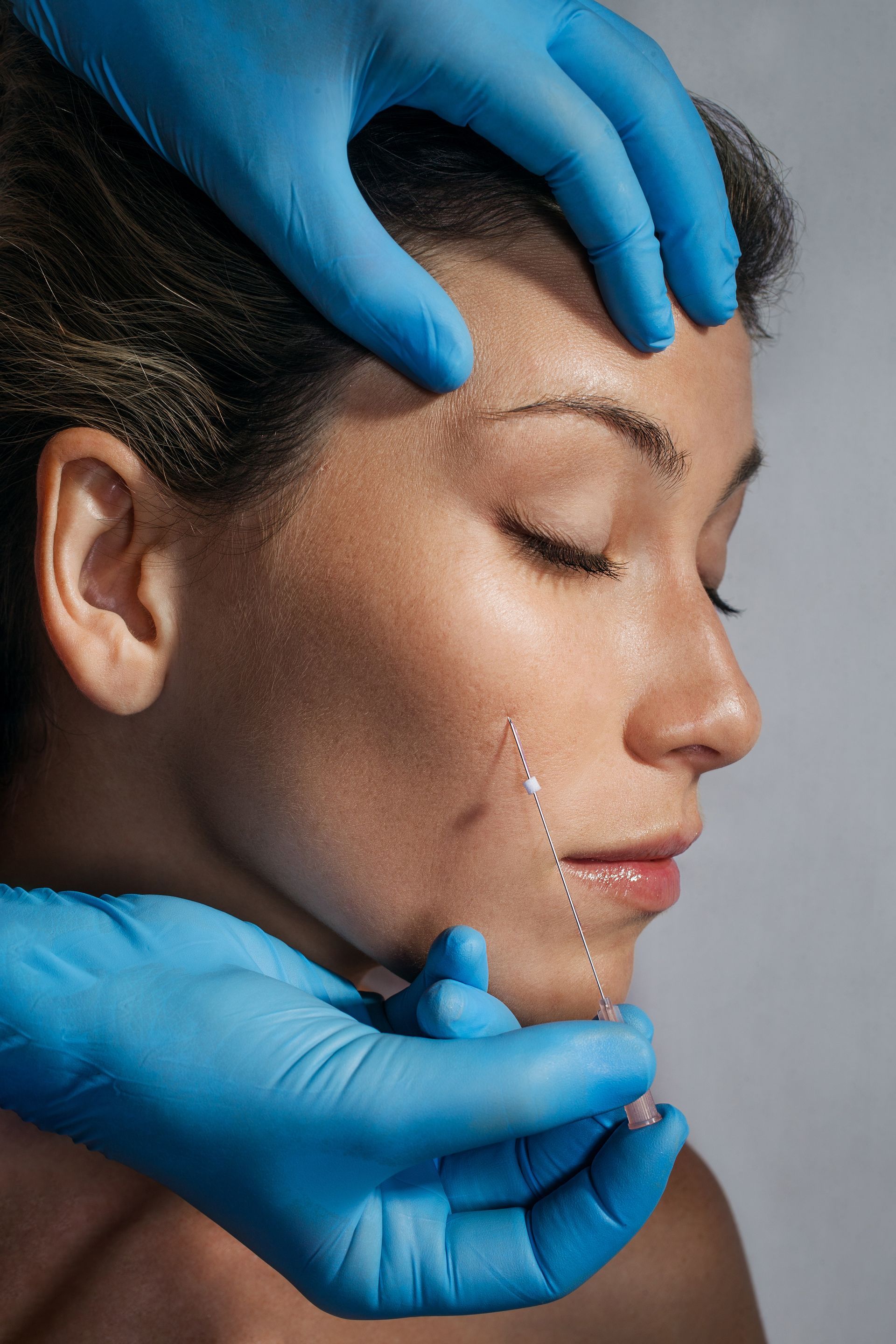 A woman is getting a botox injection in her face.