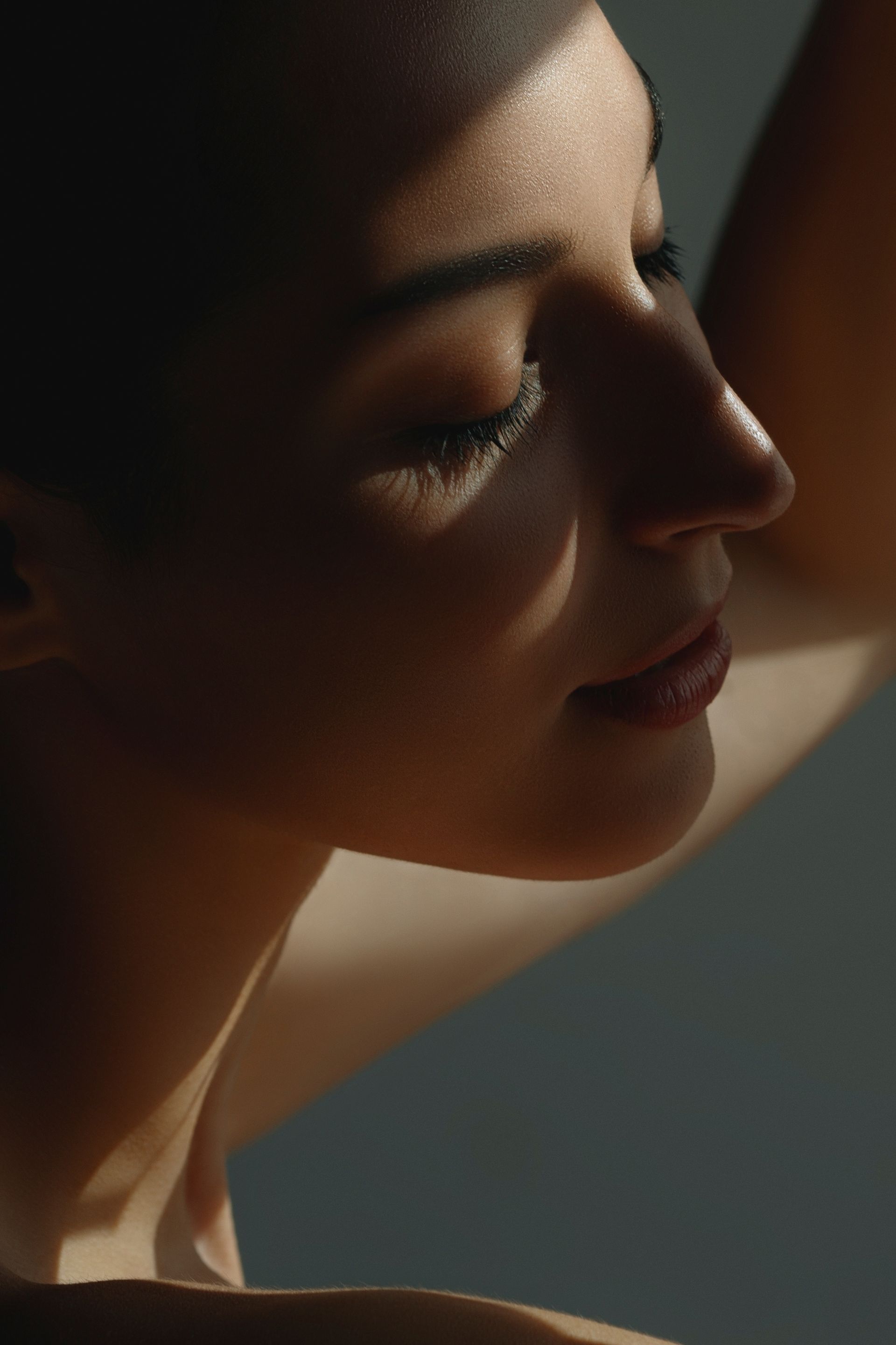 A close up of a woman 's face with a shadow on her face.