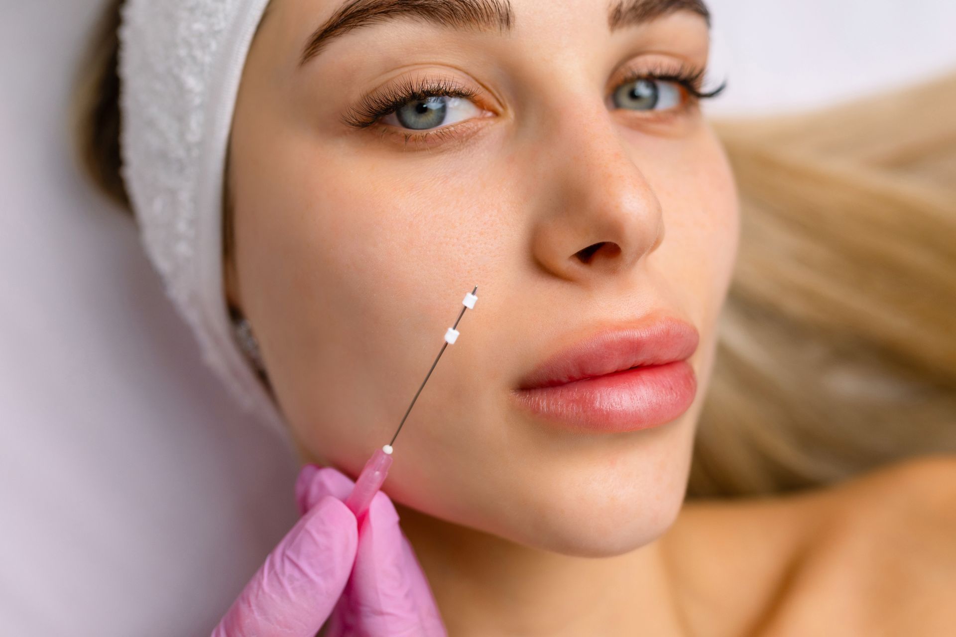 A woman is getting a botox injection in her face.