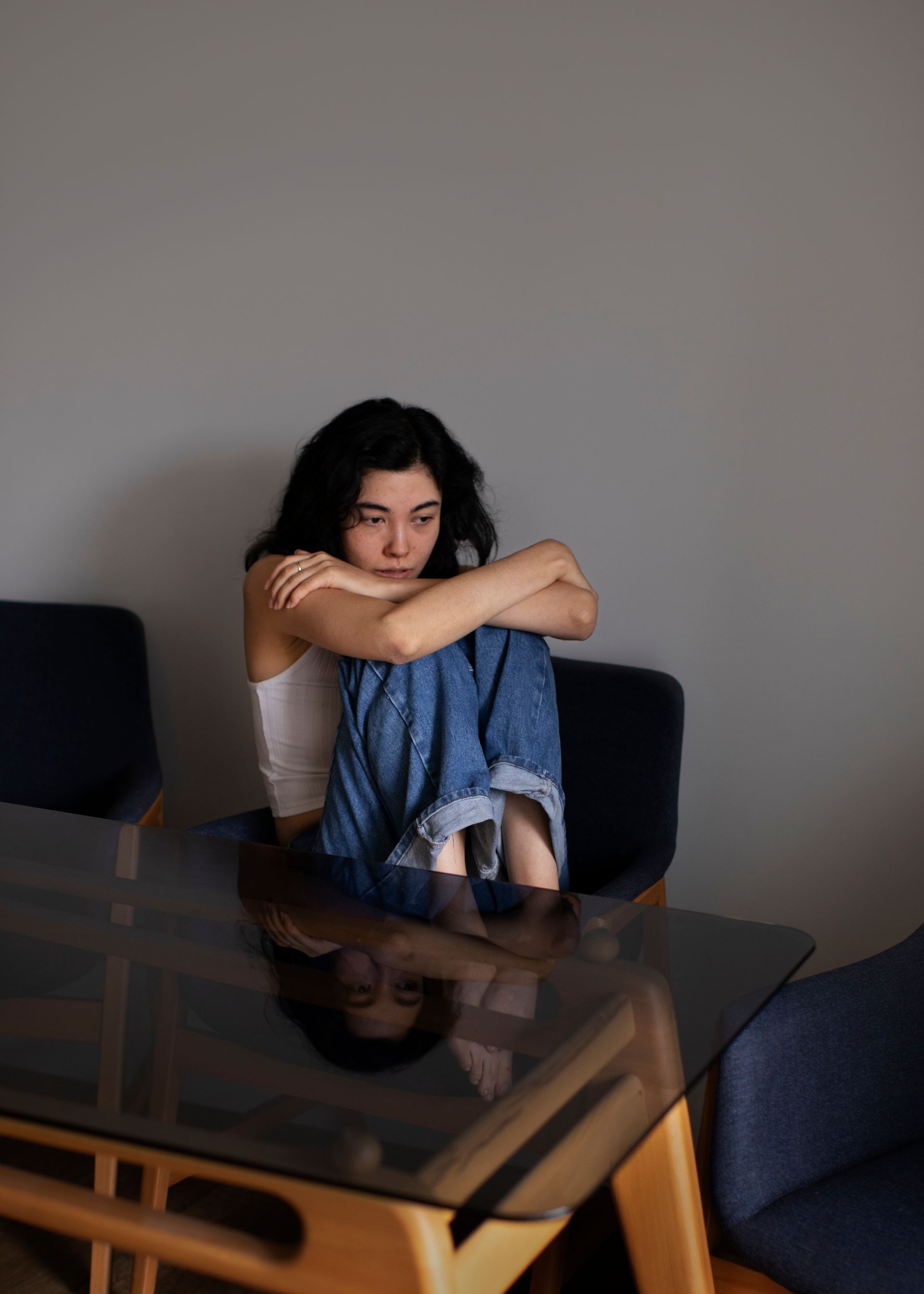 A woman is sitting at a table with her legs crossed.