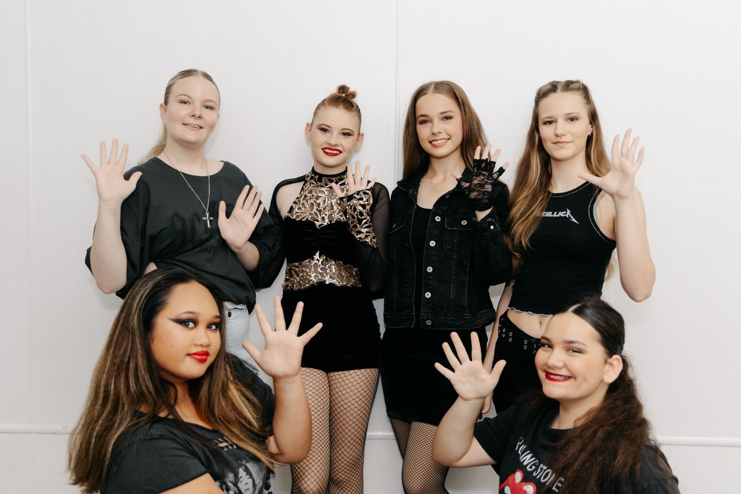 Six Individuals in Dark Clothing Stand and Sit Against a White Wall — Mc Dynamic Studio in Currajong, QLD